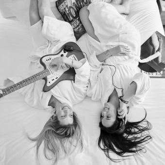 Cumberland Hotel - Two Women on a Bed Playing Guitar