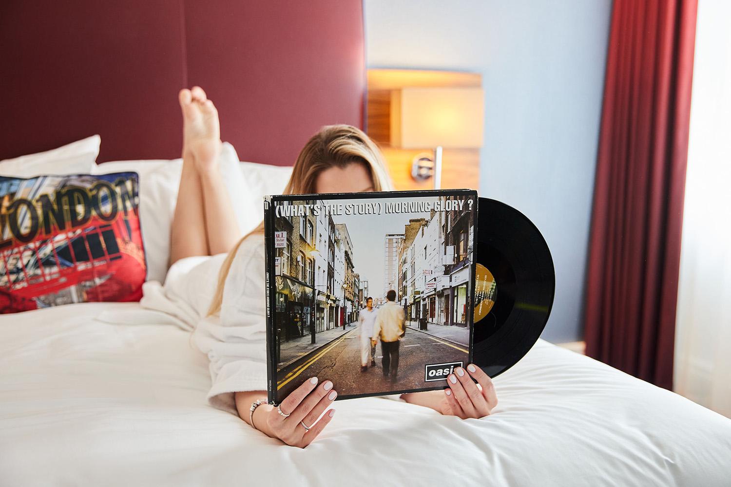 The Cumberland Hotel - Person Looking at a Vinyl on the Bed