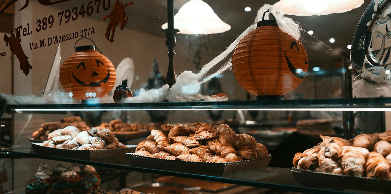 A cafe with a display of pastries and halloween decorations