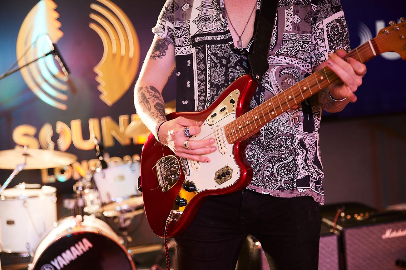 A close up of a man playing a rock guitar in The Sound Bar at The Cumberland Hotel